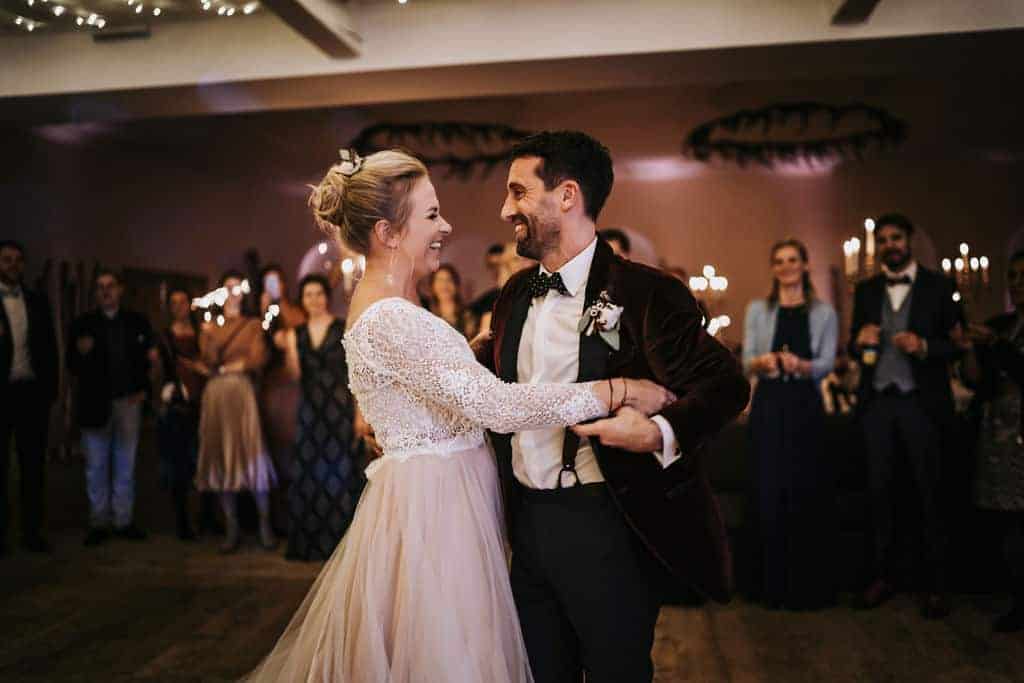 Ein überglückliches Brautpaar bei ihrem Hochzeitstag, die Hochzeitsgäste stehen im Kreis um das Brautpaar und haben Sprühkerzen in ihren Händen, was die romantische Stimmung perfekt macht. Hochzeitsplanerin pure passion weddings by Anna Walch