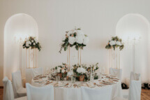 Elegante Tischdekoration bei einer Hochzeit mit einem pompösen Centerpiece in den Farben kupfer weiß blush grün