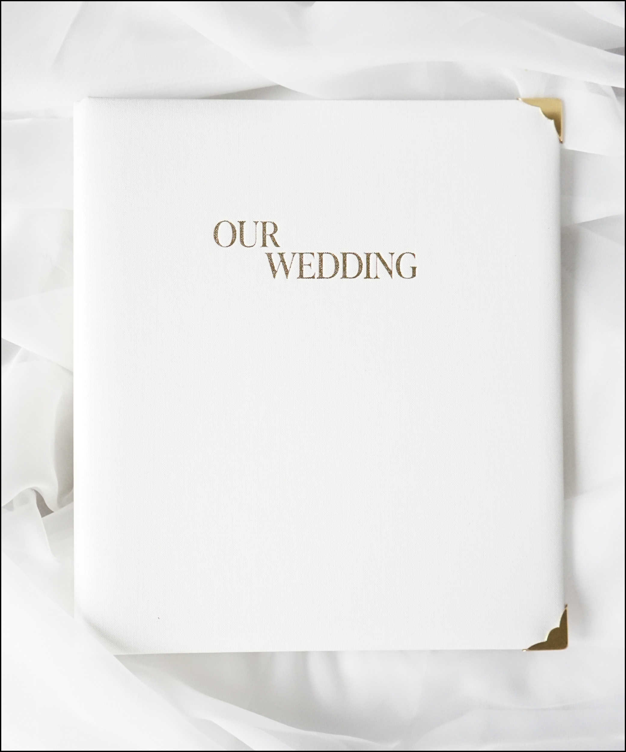 Dieses Bild zeigt die Vorderseite des Buchcovers des Premium DIY Hochzeitsplaners. Das Buchcover ist aus hochwertigem weißem Leinen gefertigt mit der goldenen Aufschrift "our wedding" und goldenen Buchecken